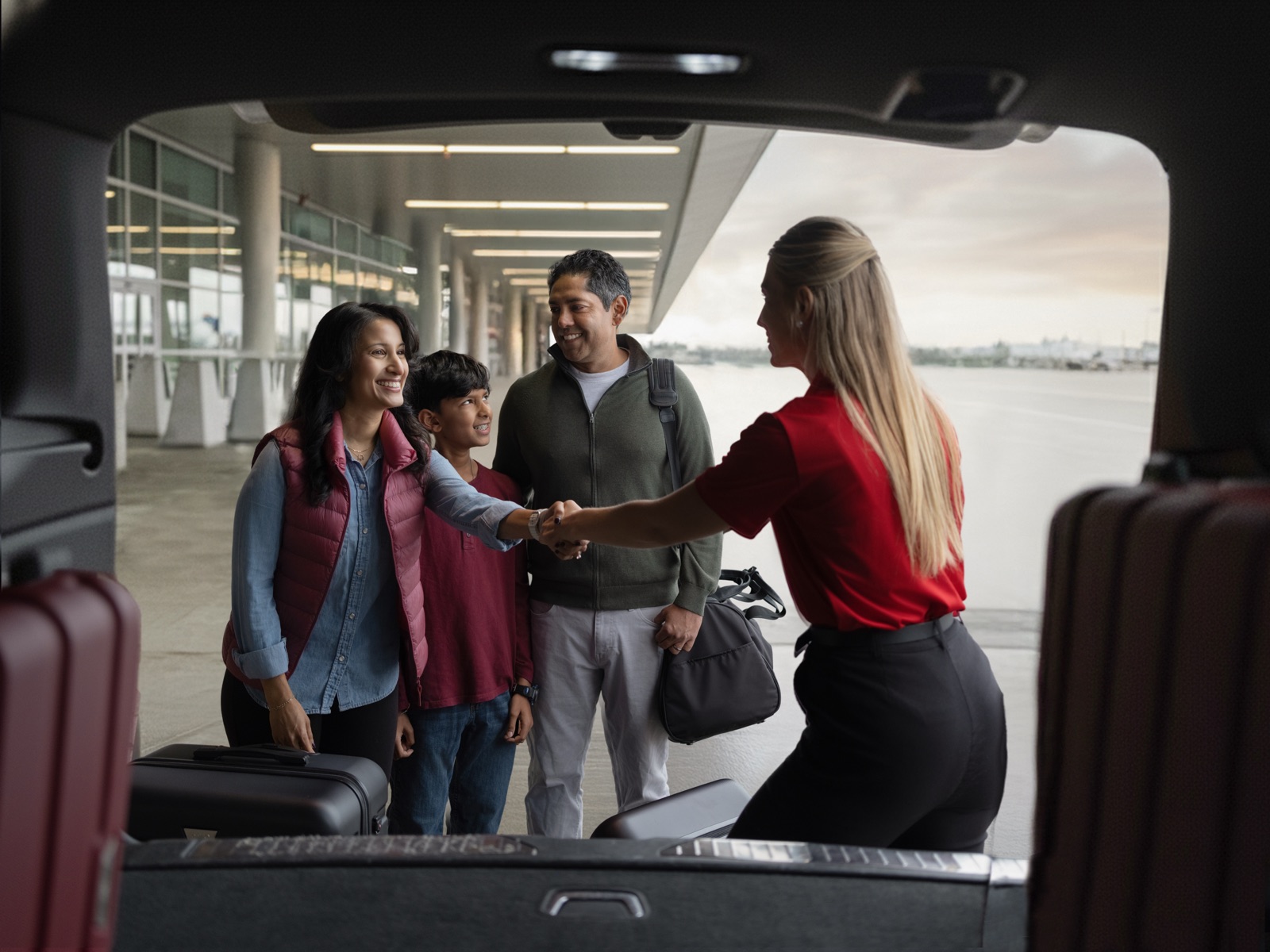Family greeting Avis agent at airport