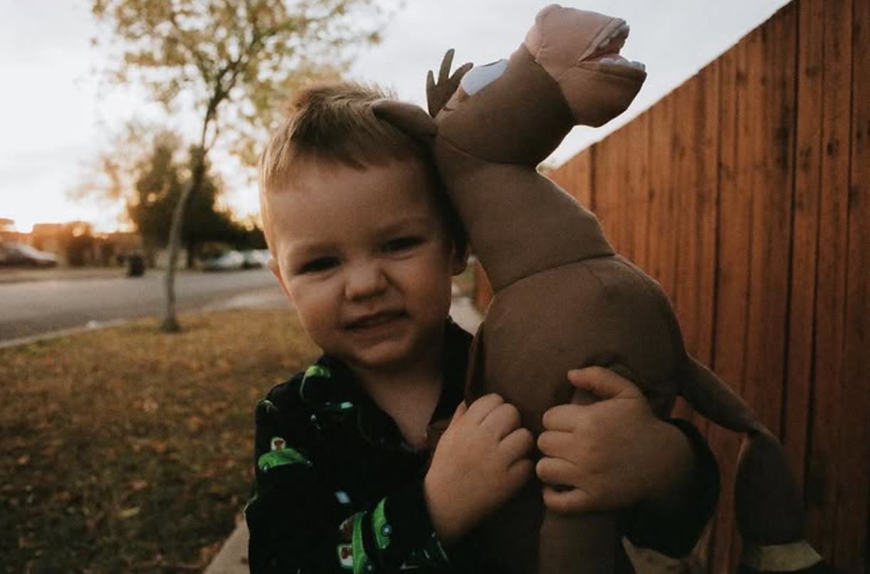 Child with dinosaur stuffed animal
