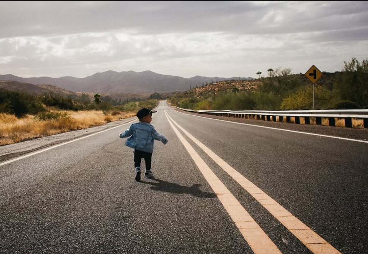 Child running on open desert road