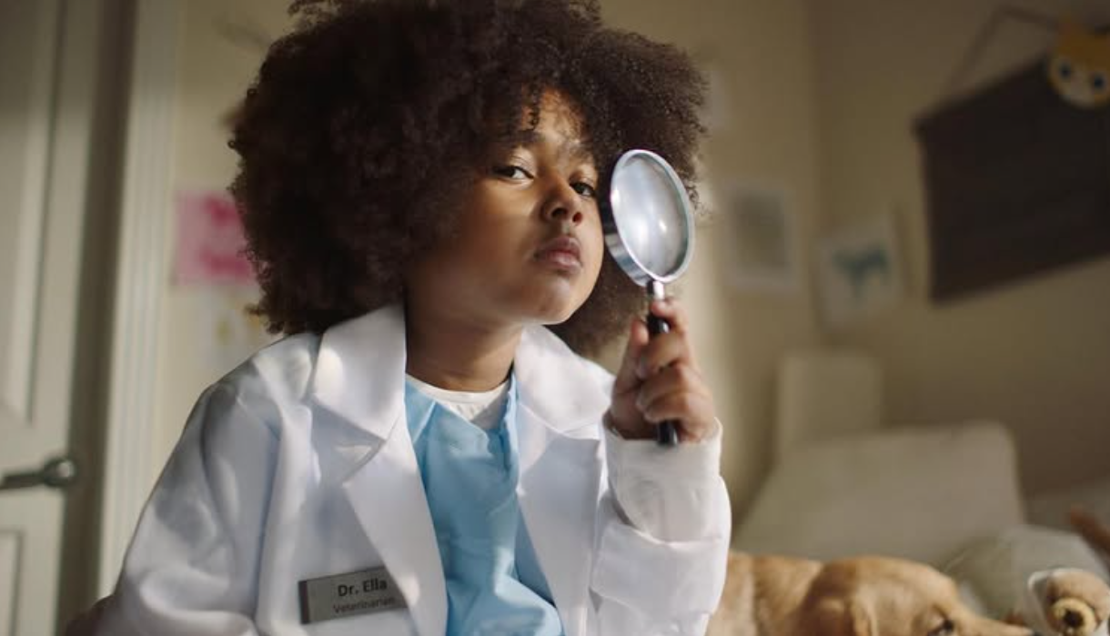Child doctor with magnifying glass — Dr. Ella