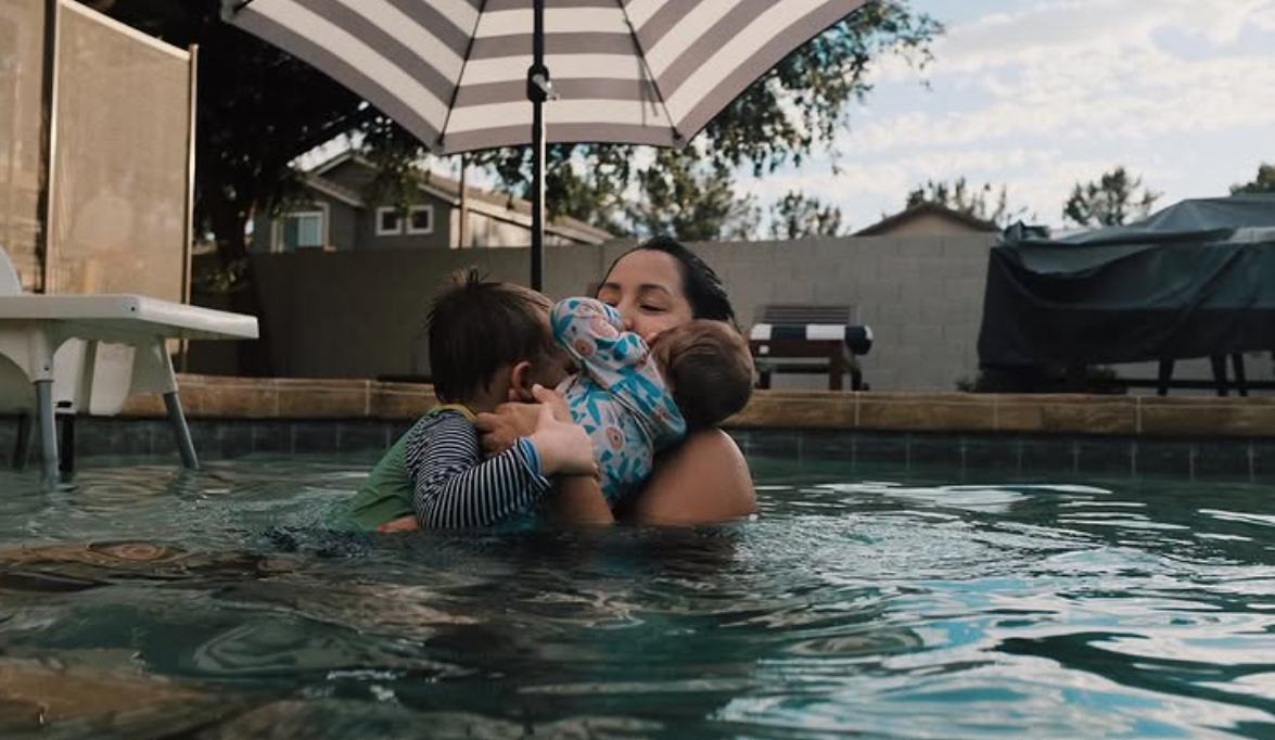 Mother hugging children in pool